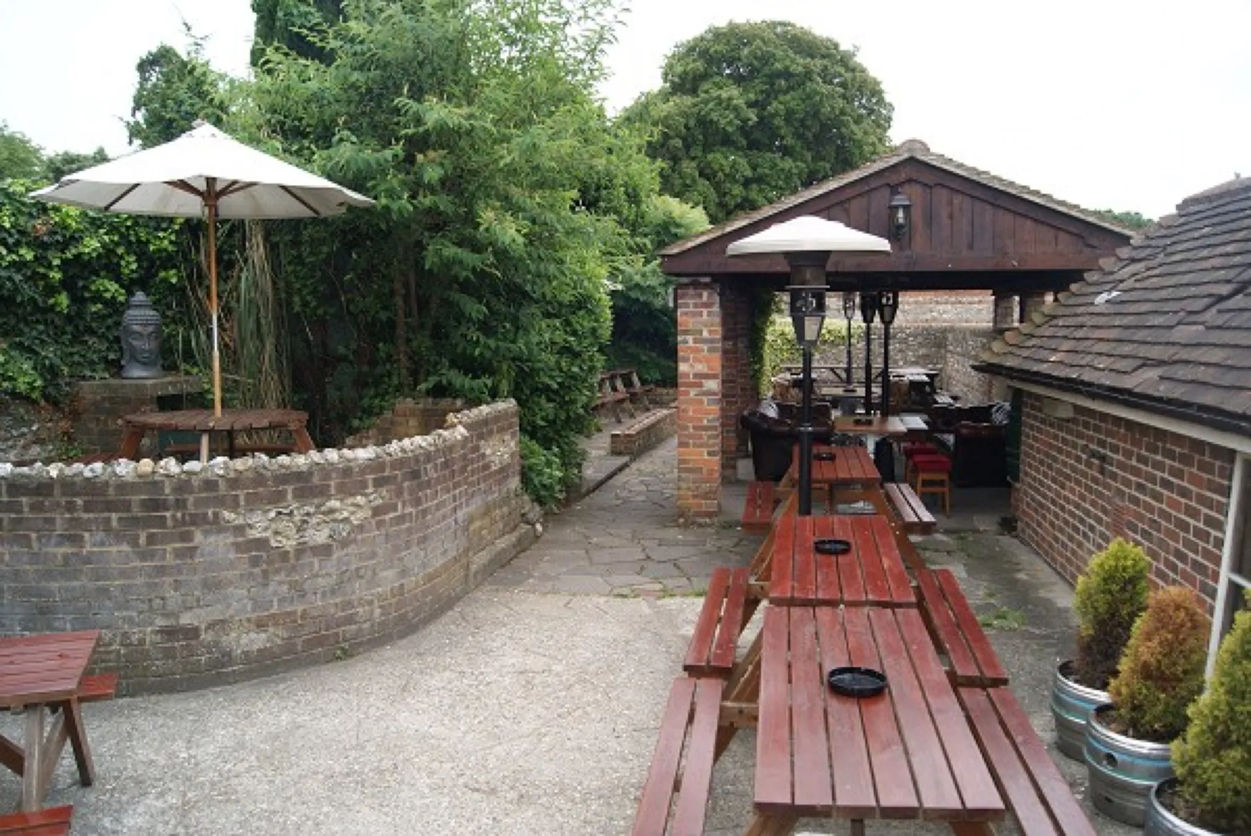 The walled courtyard garden with parasols and covered seating